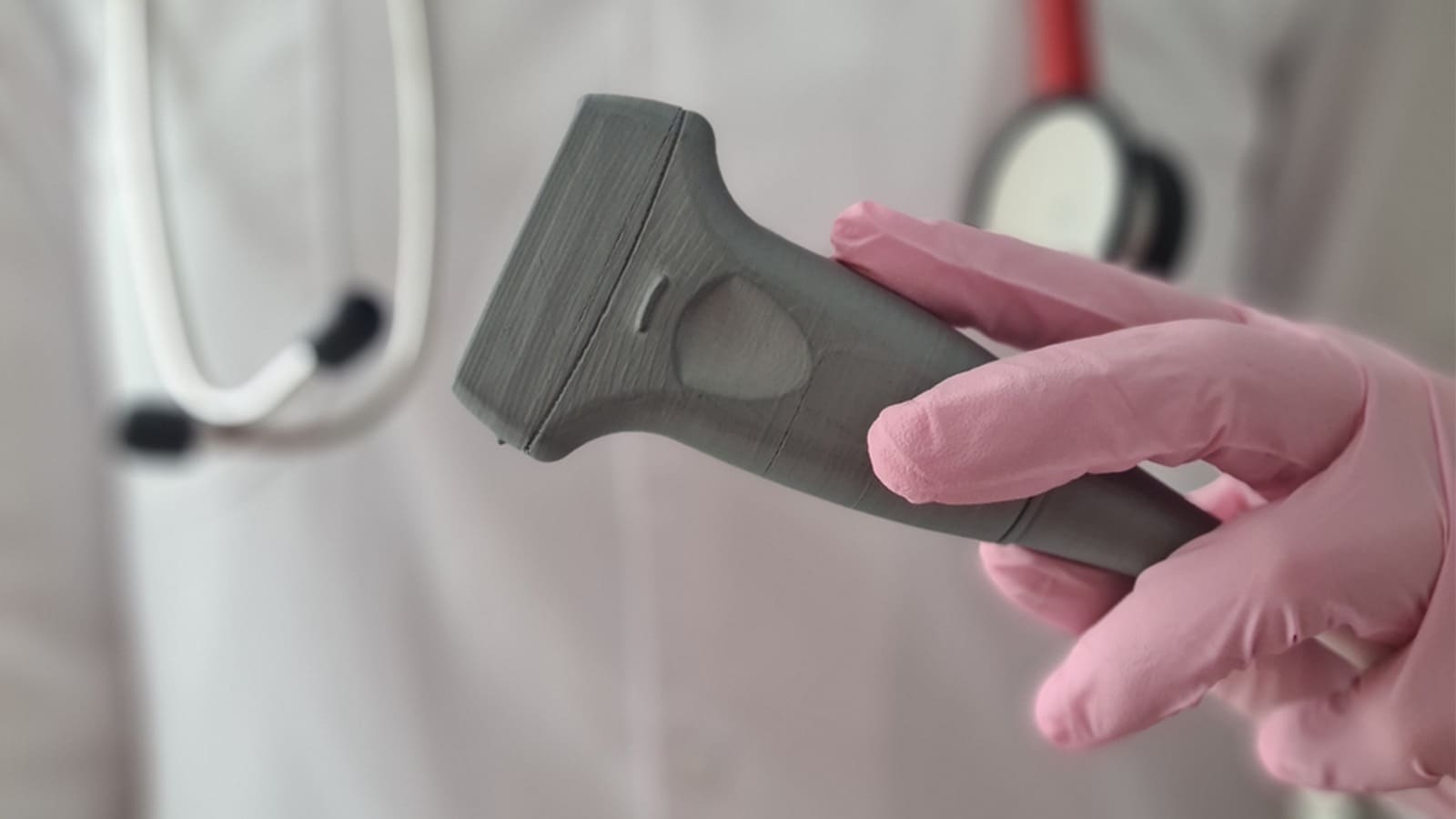 Hand with pink gloves holding doppler ultrasound probe