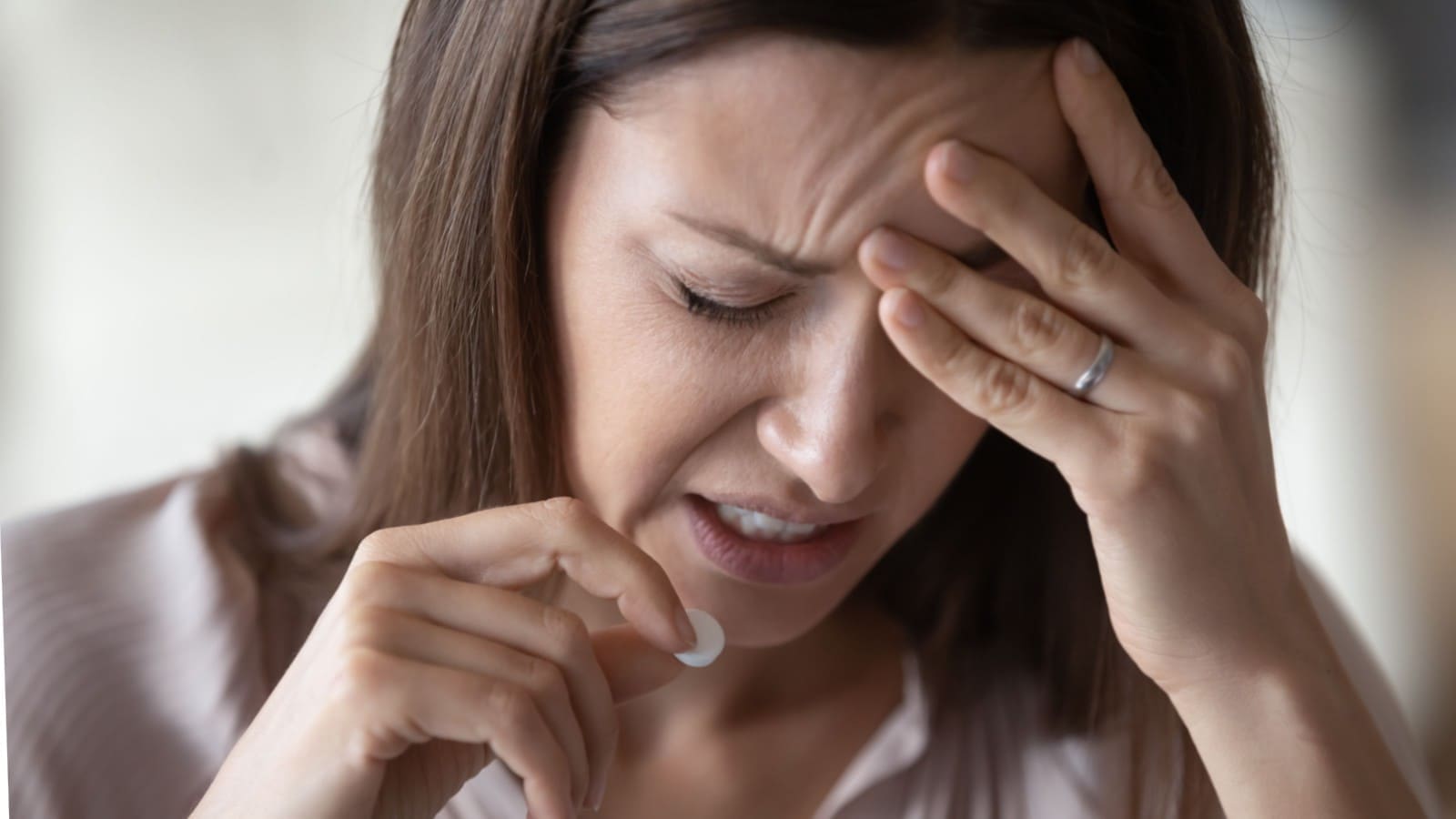 Woman suffering from a migraine taking medication